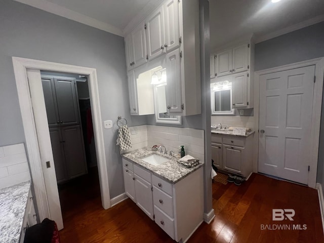 kitchen with white cabinets, light stone counters, backsplash, and dark hardwood / wood-style floors