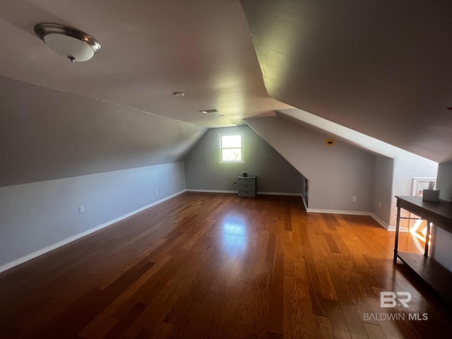 bonus room with lofted ceiling and light wood-type flooring