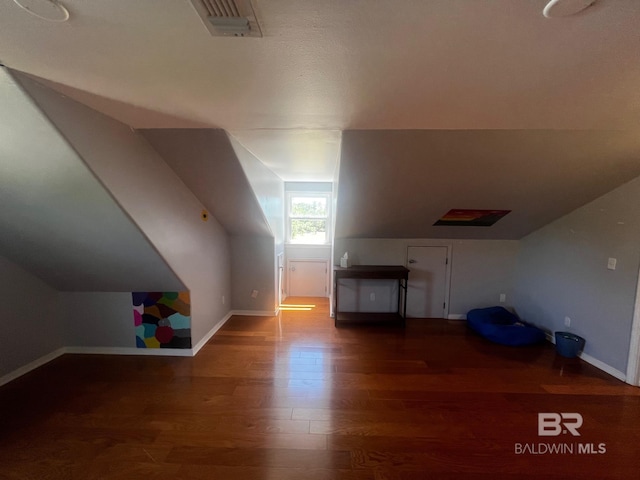 bonus room featuring dark wood-type flooring and vaulted ceiling