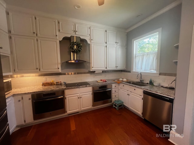 kitchen featuring white cabinets, dark hardwood / wood-style flooring, wall chimney range hood, stainless steel appliances, and sink