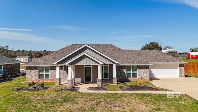 craftsman inspired home with driveway, a shingled roof, a garage, and a front lawn