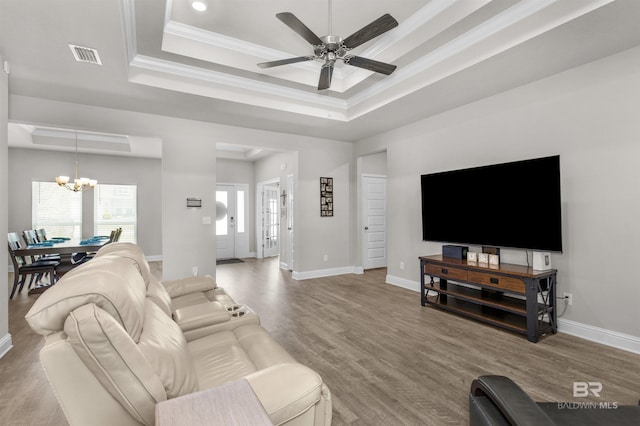 2345 Laurel St, Semmes, AL 36575 - living room featuring a tray ceiling, a chandelier, a ceiling fan, crown molding, and wood finished floors