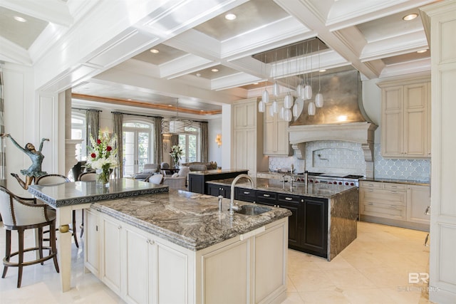 kitchen with a spacious island, cream cabinets, and sink