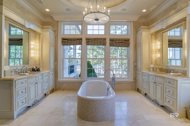 bathroom with ornamental molding, vanity, an inviting chandelier, and a relaxing tiled tub