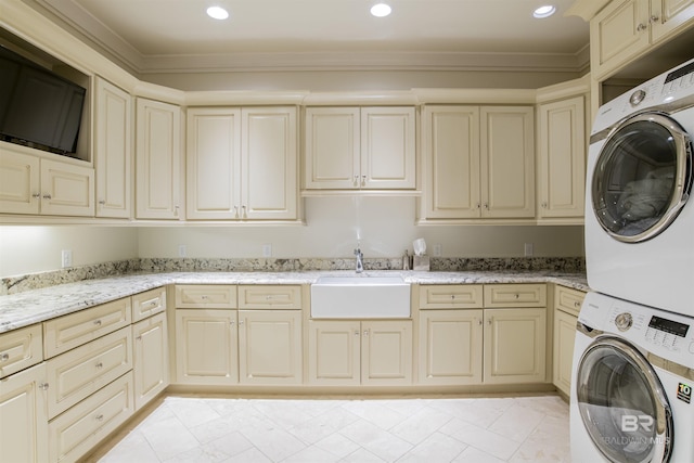 laundry area with sink, stacked washing maching and dryer, and crown molding