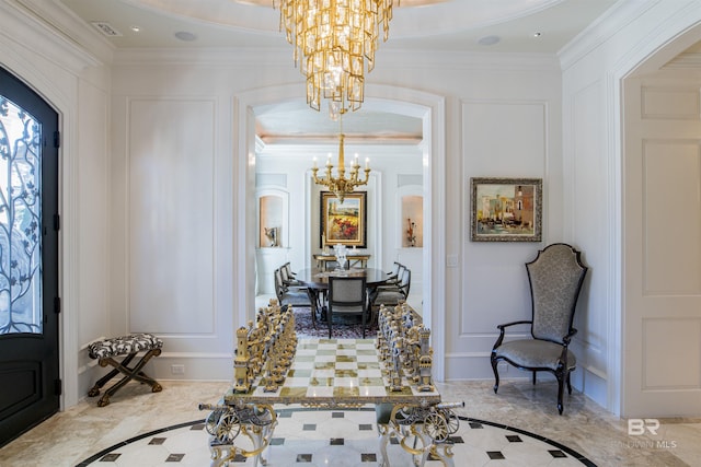 entryway with crown molding and a chandelier