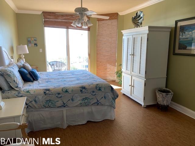 bedroom featuring brick wall, ornamental molding, ceiling fan, and hardwood / wood-style flooring