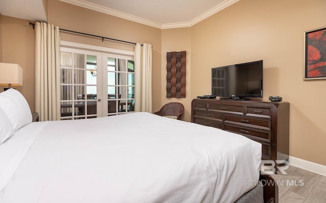 bedroom with baseboards, wood finished floors, crown molding, and french doors