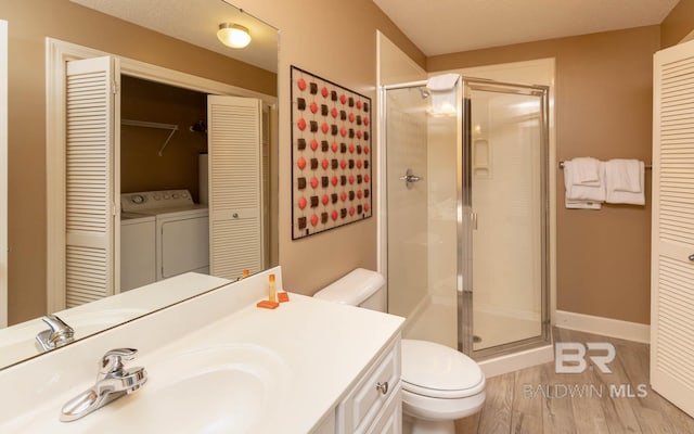 full bath with a closet, toilet, a stall shower, vanity, and wood finished floors