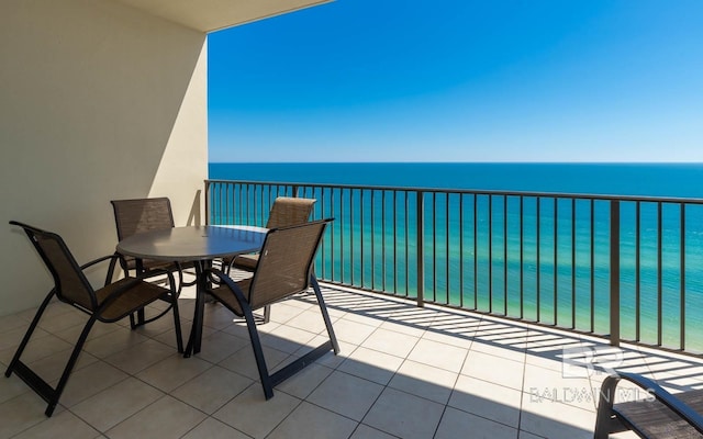 balcony with a water view and outdoor dining space