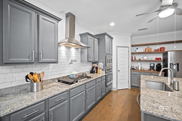 kitchen featuring sink, gray cabinets, appliances with stainless steel finishes, light stone counters, and wall chimney exhaust hood