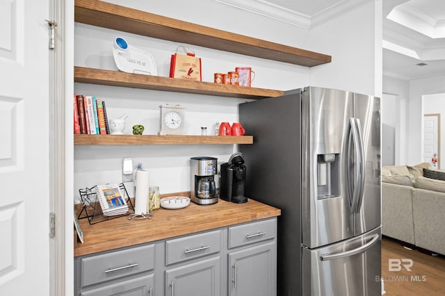 kitchen featuring dark hardwood / wood-style flooring, crown molding, stainless steel fridge, and gray cabinets