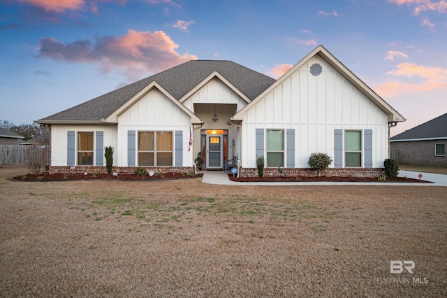 modern farmhouse style home featuring a lawn