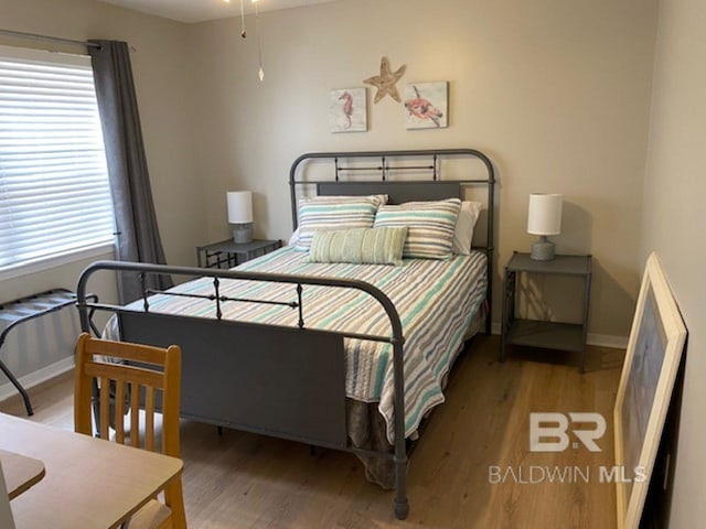 bedroom featuring multiple windows and light wood-type flooring