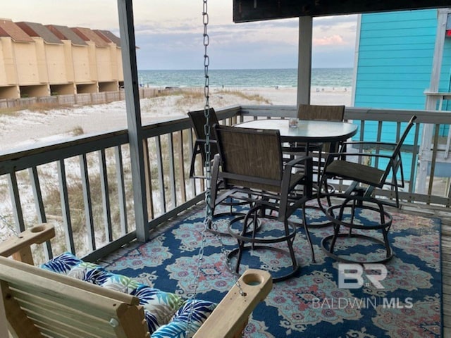 balcony featuring a view of the beach and a water view