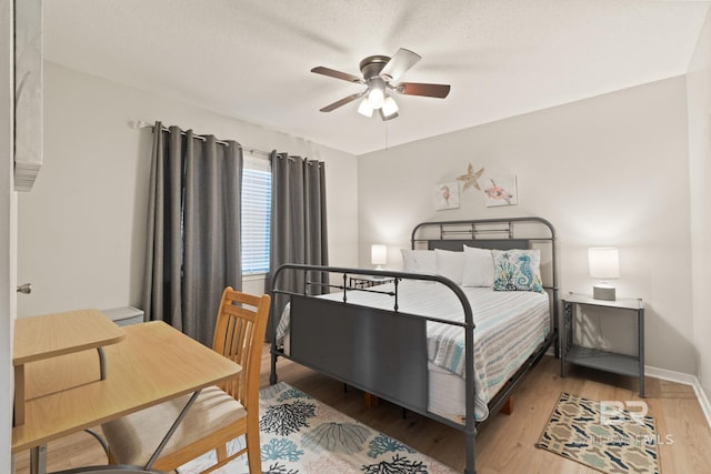 bedroom featuring ceiling fan, a textured ceiling, and light wood-type flooring