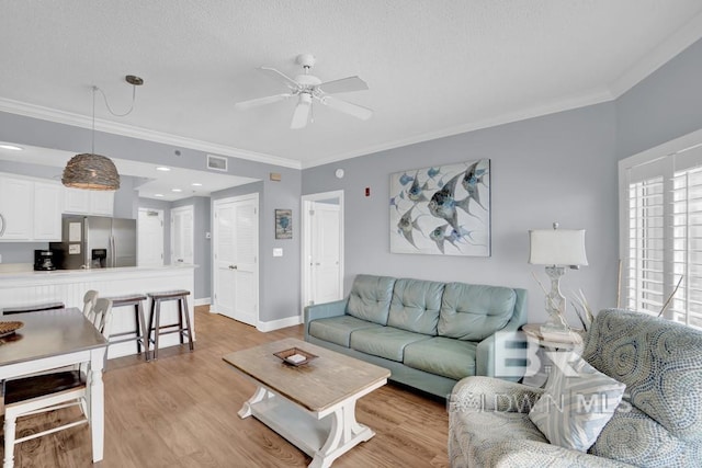 22984 Perdido Beach Blvd Unit 52D, Orange Beach, AL 36561 - living room with a ceiling fan, crown molding, light wood-style floors, baseboards, and visible vents