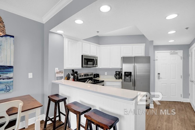 22984 Perdido Beach Blvd Unit 52D, Orange Beach, AL 36561 - kitchen with light wood finished floors, stainless steel appliances, a peninsula, crown molding, and a breakfast bar area