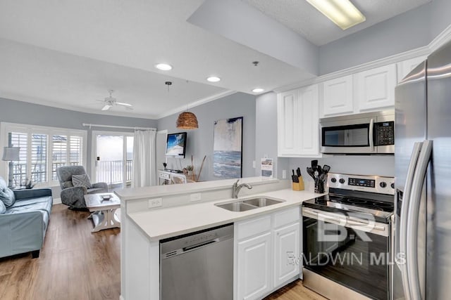 22984 Perdido Beach Blvd Unit 52D, Orange Beach, AL 36561 - kitchen with a peninsula, a sink, open floor plan, light wood-style floors, and appliances with stainless steel finishes