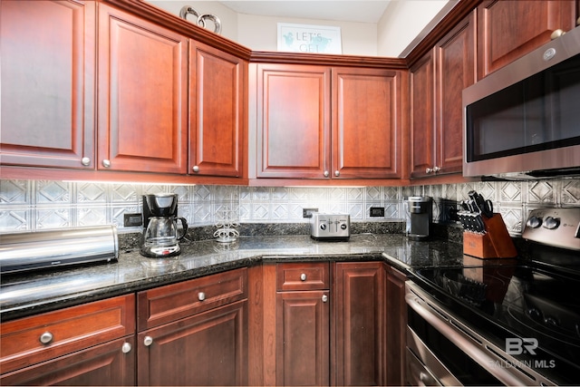 kitchen featuring dark stone countertops, decorative backsplash, and stainless steel appliances