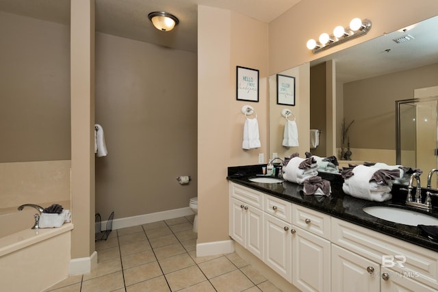 bathroom with a tub to relax in, tile patterned flooring, vanity, and toilet