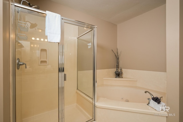 bathroom featuring separate shower and tub and a textured ceiling