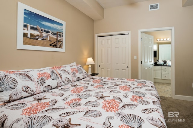 carpeted bedroom with ensuite bath and a closet