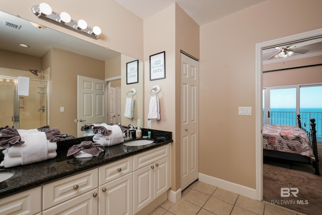 bathroom featuring ceiling fan, tile patterned flooring, an enclosed shower, a water view, and vanity