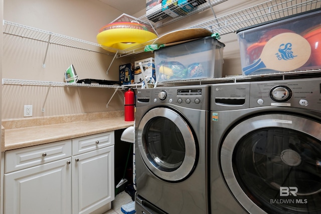 laundry room featuring cabinets and washing machine and clothes dryer