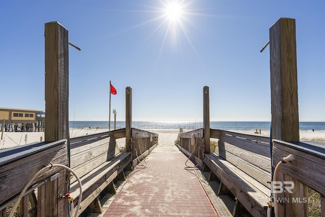 view of property's community with a water view and a beach view