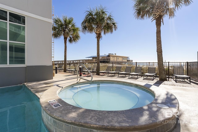 view of swimming pool featuring a patio and a hot tub