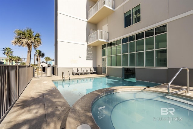 view of swimming pool featuring a hot tub