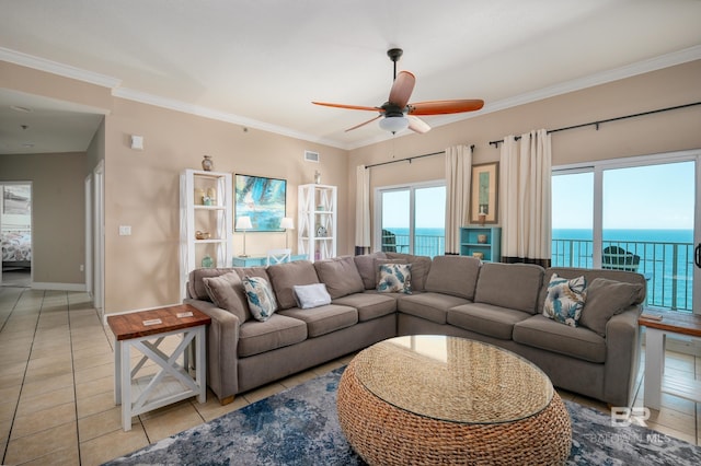 tiled living room featuring ceiling fan, crown molding, and a water view