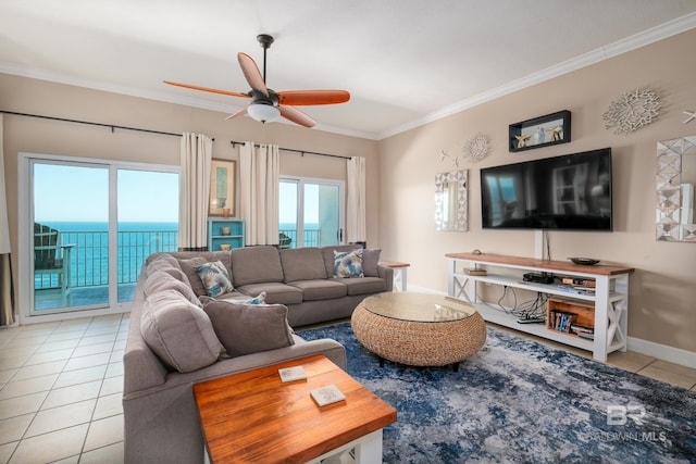 tiled living room with a wealth of natural light, a water view, ornamental molding, and ceiling fan