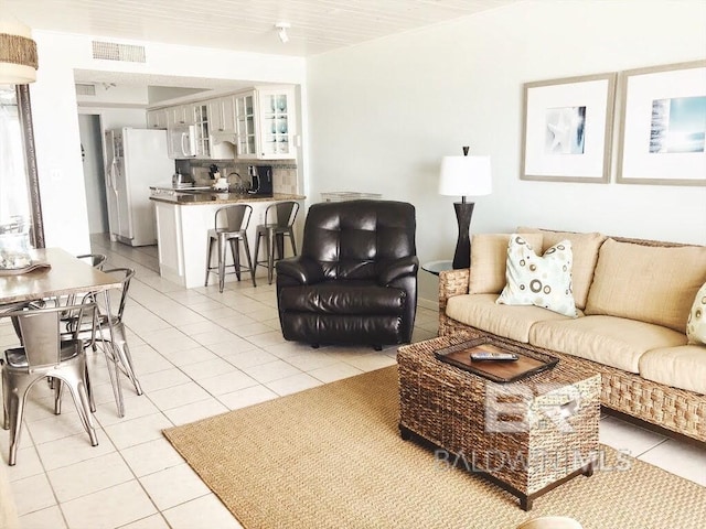 living area with light tile patterned floors and visible vents