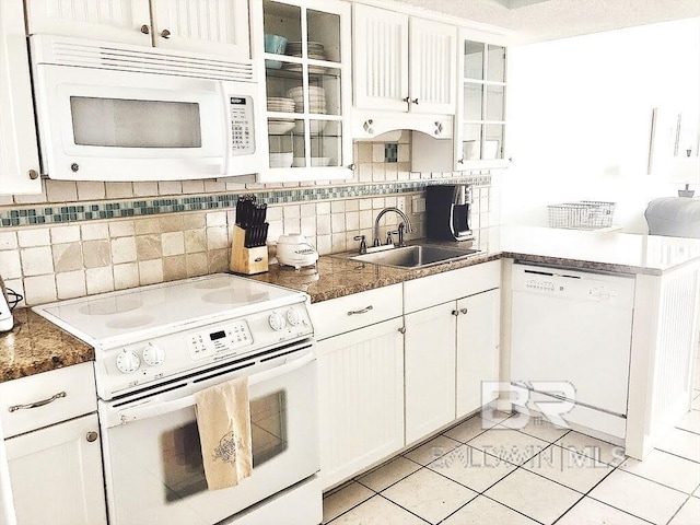 kitchen featuring tasteful backsplash, glass insert cabinets, white cabinetry, a sink, and white appliances