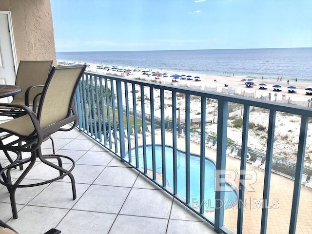 balcony featuring a water view and a view of the beach