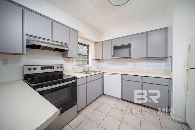 kitchen featuring a sink, white appliances, gray cabinetry, and under cabinet range hood