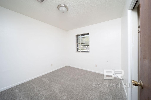 carpeted spare room with baseboards and a textured ceiling