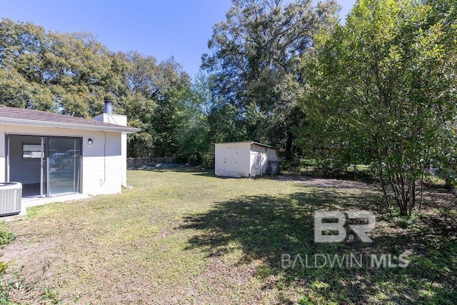view of yard featuring central air condition unit, a storage unit, and an outdoor structure