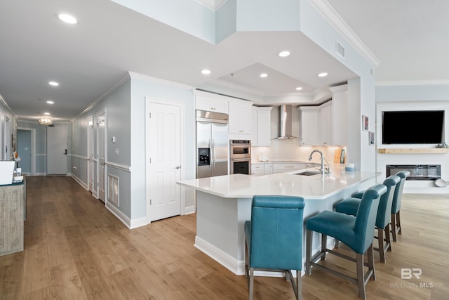 28250 Canal Rd Unit 101, Orange Beach, AL 36561 - kitchen with visible vents, wall chimney exhaust hood, appliances with stainless steel finishes, a peninsula, and a sink