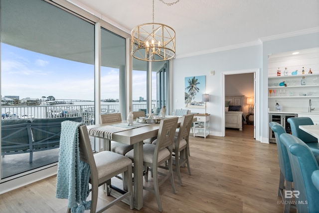 28250 Canal Rd Unit 101, Orange Beach, AL 36561 - dining area featuring ornamental molding, light wood-type flooring, beverage cooler, and an inviting chandelier