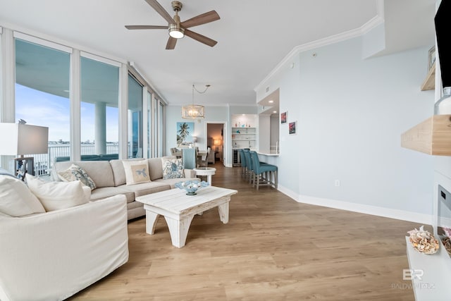 28250 Canal Rd Unit 101, Orange Beach, AL 36561 - living area with ceiling fan with notable chandelier, baseboards, ornamental molding, light wood-type flooring, and floor to ceiling windows