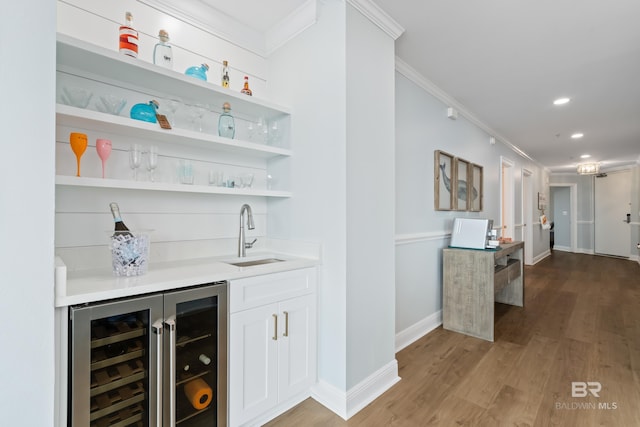 28250 Canal Rd Unit 101, Orange Beach, AL 36561 - bar featuring wine cooler, wet bar, ornamental molding, a sink, and light wood-type flooring