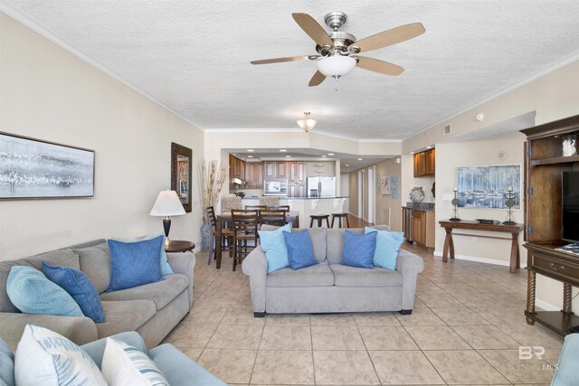 tiled living room with ceiling fan, a textured ceiling, and ornamental molding