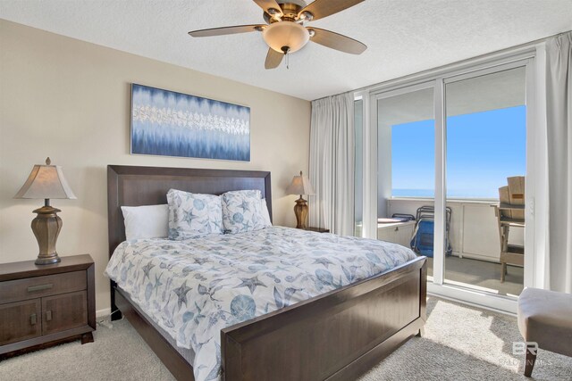 carpeted bedroom with ceiling fan and a textured ceiling