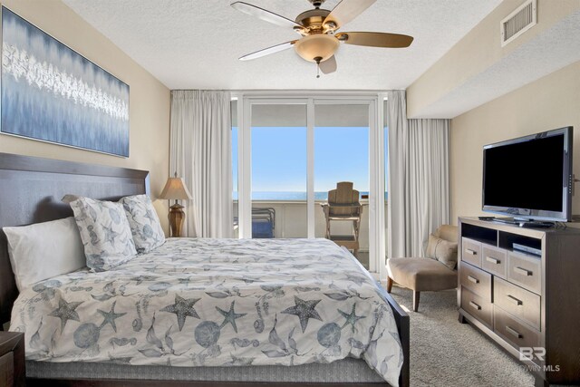 bedroom with ceiling fan, a textured ceiling, carpet floors, and access to exterior