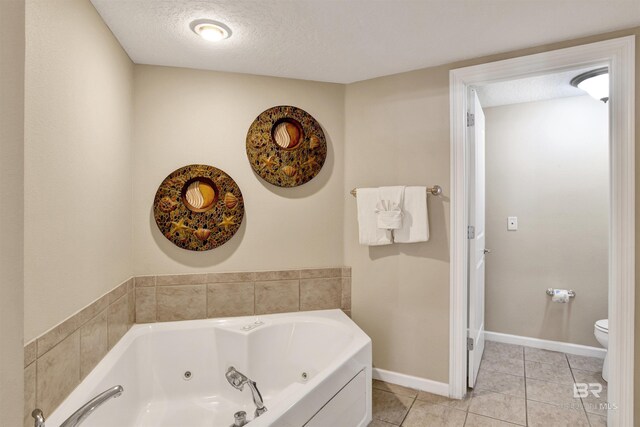 bathroom with a textured ceiling, toilet, a bathing tub, and tile patterned flooring