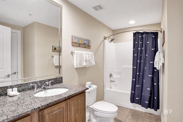 full bathroom featuring tile patterned flooring, toilet, shower / bath combo with shower curtain, and vanity