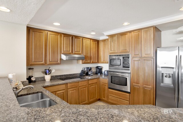 kitchen featuring appliances with stainless steel finishes, sink, dark stone countertops, and crown molding